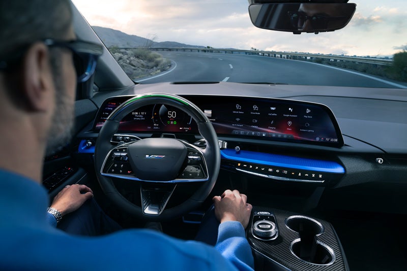 Front View of the 2026 OPTIQ-V Driving Through the Dusk Utilizing its Headlights | House Cadillac in OWATONNA MN